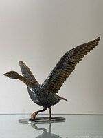 Right side view of goose sculpture with wings raised, showing profile and detailing