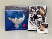 Overview photo showing all three collectible sets including the 1972 Hockey Series proof set, the Millennium Keepsake 2000 shaped like a bird, and a smaller sealed collectible.