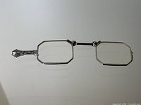 Full unfolded view of eyeglasses showing octagonal lenses and folding bridge