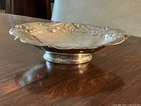 Side view showing the low pedestal base and scalloped floral border.