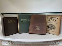 Four vintage art books arranged on a shelf: The Artist's London, Schaeffer Galleries, Great Pictures by Great Painters, and Currier & Ives.