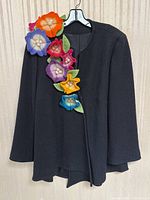 Front view of black wool jacket with multicolored felt flowers