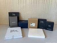 View of all boxed gift items on table showing Folio Home branded boxes, Bowring box, and other assorted boxed items.