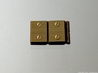 Top-down view of two gold links side by side on reflective surface