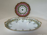 Cauldon pansy plate displayed behind Limoges Lily of the Valley serving dish