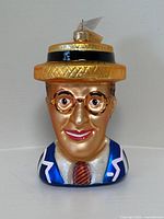 Front view of Harold Lloyd glass ornament showing detailed face, glasses, hat, and upper clothing.