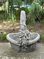 Front view of concrete garden basket decor planter with ornate handle and bow.