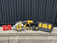 Full view of DeWalt drill, saw, batteries, charger, tool bag, and Milwaukee bit set