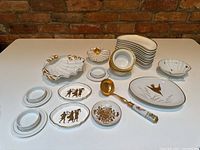 Full view of white and gold porcelain dish assortment on table