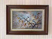 Full view of the framed oil painting showing two chickadees on a branch
