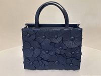 Front view showing navy leather and three-dimensional floral appliqués covering front panel