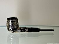 Side view of the Medico pipe showcasing the full length and the sterling silver overlay pattern on black.