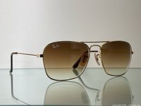 Front three-quarter view showing gold metal frame and gradient brown lenses