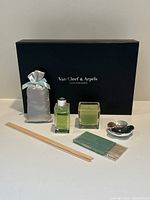 Full set of Van Cleef & Arpels diffuser and incense, including candle, diffuser oil, incense sticks, incense holder, reed sticks, and pouch.