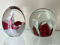 Both paperweights side by side on reflective surface