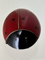 Close-up front view showing the red Bakelite body with black spots and black Bakelite head with metallic eyes.