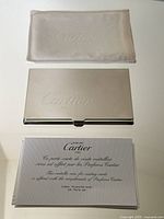 Card case, pouch and promotional card arranged on white surface
