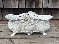 Front view of planter on wooden surface against shingled background.