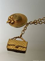 Close-up of straw hat and quilted handbag charms showing texture and detail