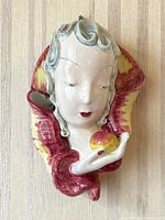 Full front view of the wall pocket showing lady’s head, ruffled collar and apple