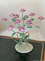 Frontal view of entire candelabra displaying five rose-shaped candle holders arranged in a circular pattern on round base