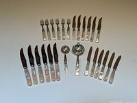 Overhead view of entire 26-piece set showing arrangement of forks, knives, and serving spoons