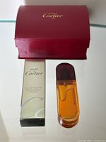The entire lot shown: 15ml perfume bottle, original packaging box, and Cartier red gift box with gold logo.