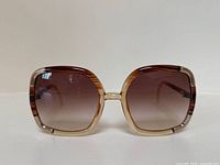 Front view showing oversized square gradient brown lenses and frame color.