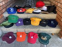 Overall lot of 18 hats arranged on concrete steps in rows