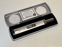 Zippo lighter in its original fitted clear plastic case with black velvet insert and guarantee card visible.