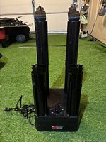 Front angled photo showing black electric shoe and boot dryer with dual vertical drying tubes on base with dial control.