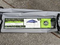Light grey Quest outdoor canopy carrying bag with product label showing specifications and branding.