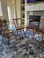Four chairs grouped on patterned rug in front of fireplace and shelving