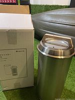 Photo of the Snow Peak Smoke Meister smoker body next to the original box showing packaging and main canister