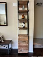 Front elevation showing full height unit against wall with decorative items on shelves