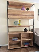 Front view of the West Elm industrial bookcase fully assembled with decorative items on shelves