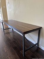 Side perspective of bench showing solid wood top and metal legs