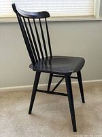 Side view of black wooden Salt Chair with spindle backrest and tapered legs.