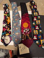 Four Disney-themed neckties laid out showing various colorful designs featuring Mickey Mouse and friends.