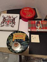 Four vintage shortbread tins on display, showing top-down view for identification