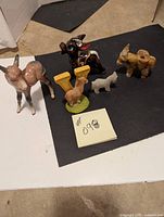 Photo showing the full set of five donkey figurines, three ceramic and two stone, in varying sizes and colors.