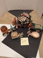 Photo showing all five ceramic donkey cart planters arranged on a black surface with a white and black background, displaying varying sizes and colors.