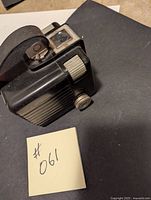 Photo of Kodak Brownie Hawkeye Flash Model camera, showing side with winding knob and viewfinder.
