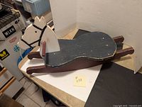 Wooden rocking horse from a side angle showing overall shape, painted horse head and seat area.