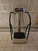 Front view of silver and black T-Zone VT-15 whole body vibration machine on tiled floor