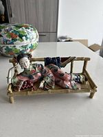 Side-angle view showing the full reclining pose and bamboo bench base.