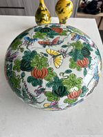 Top view of a porcelain bowl showing the colorful floral and butterfly pattern covering the surface.