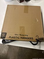 Box labeled 'Ultra Heavy-duty Plastic Hangers' containing 12 pack of hangers in new condition.