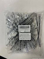 Plastic bag containing 24 black Cat6a Ethernet patch cables, each with transparent connectors and boots.