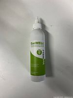 Single bottle of EarWELL Otic Cleansing Solution with green label and white nozzle on white background.